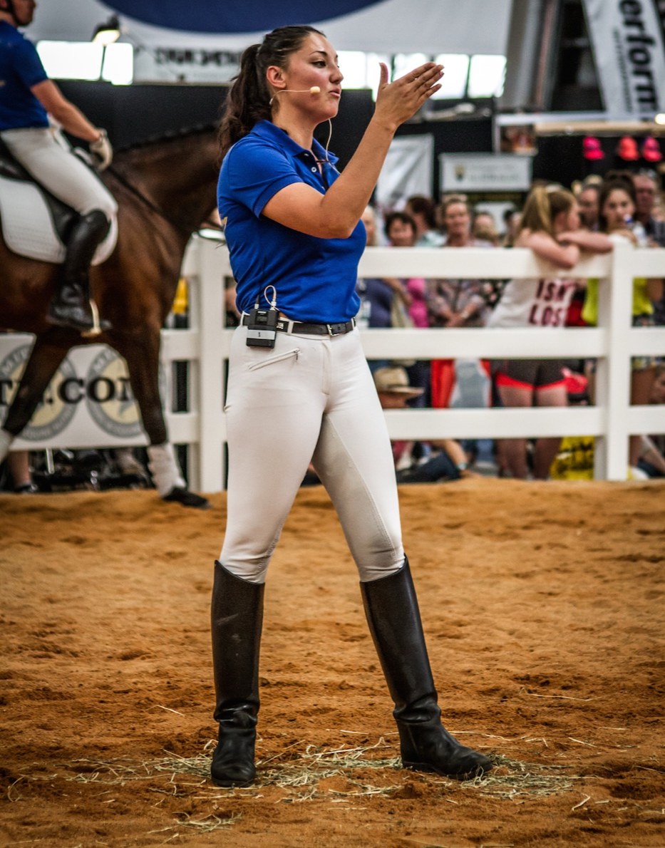 Natasha Althoff standing in the arena watching a rider ride past her